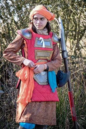 Bright colours and patterned fabrics; the simpler clothing is accentuated with light armour decorated with flaming reds and oranged